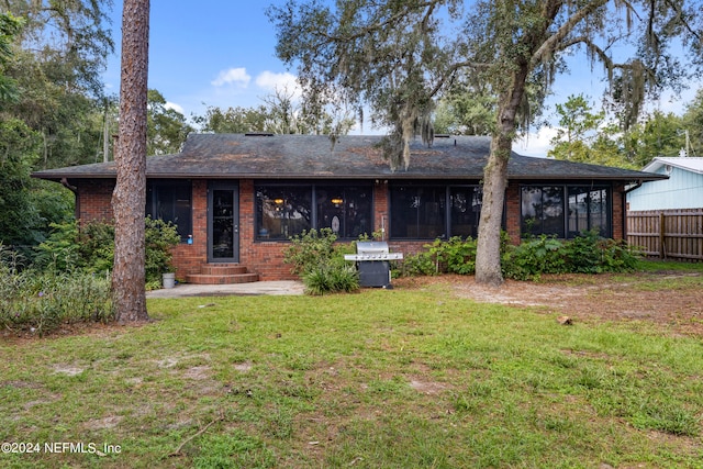 back of house with a sunroom and a yard