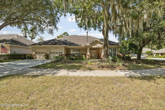 single story home with a garage and a front lawn