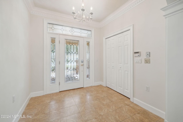 tiled foyer featuring crown molding and a chandelier