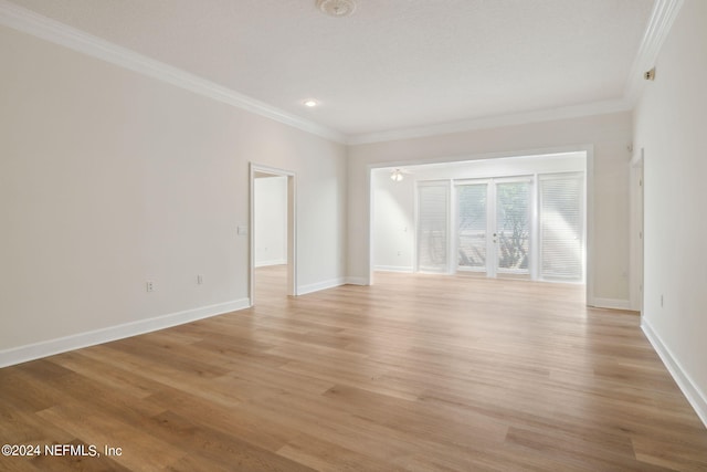 spare room featuring light hardwood / wood-style floors and ornamental molding