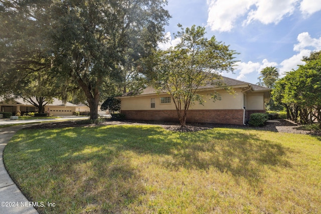 view of side of home with a lawn and a garage