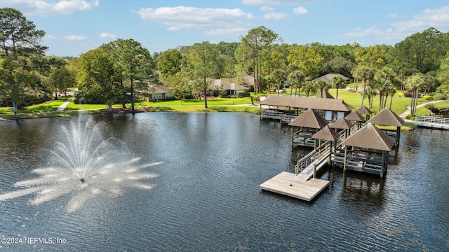 view of dock featuring a lawn and a water view