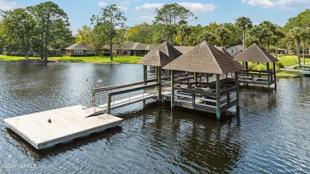 view of dock with a water view and a yard