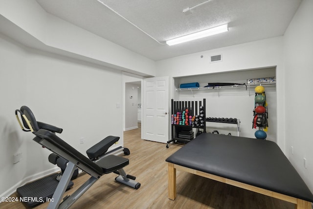 exercise room with a textured ceiling and hardwood / wood-style flooring