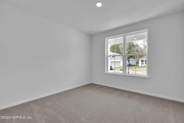 carpeted empty room with baseboards