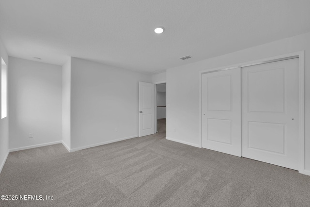 unfurnished bedroom featuring carpet flooring, visible vents, and baseboards