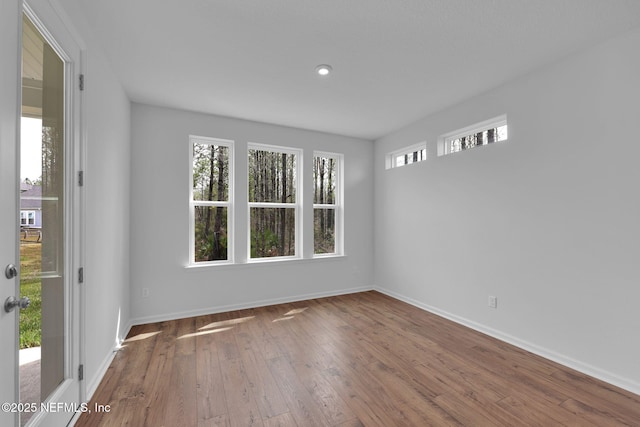 spare room with hardwood / wood-style floors and baseboards