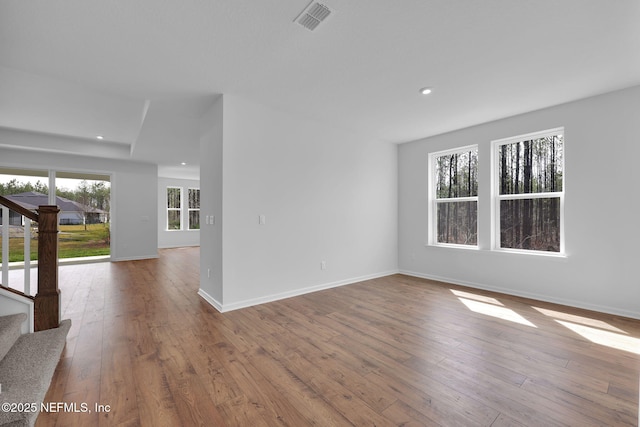 unfurnished room with recessed lighting, visible vents, baseboards, stairs, and light wood-style floors