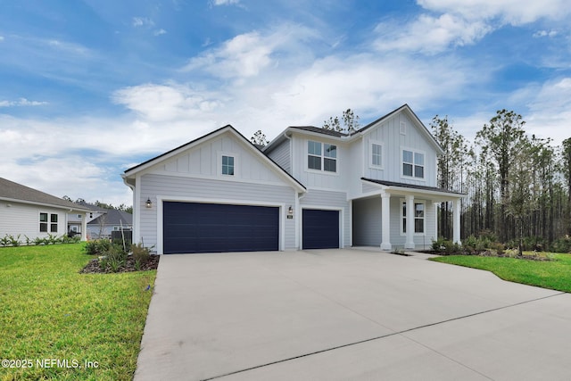 modern farmhouse featuring an attached garage, concrete driveway, board and batten siding, and a front yard