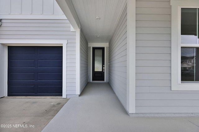 view of exterior entry with a garage and board and batten siding