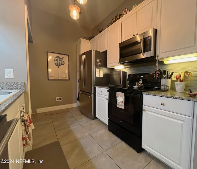 kitchen featuring light tile patterned floors, tasteful backsplash, stone countertops, white cabinetry, and stainless steel appliances