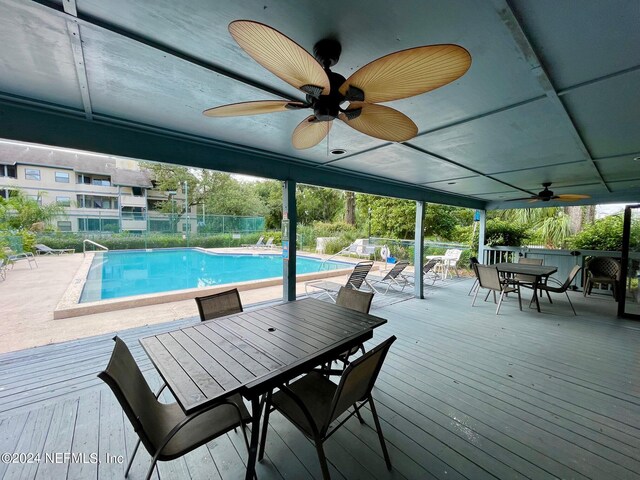 view of swimming pool featuring a deck and ceiling fan