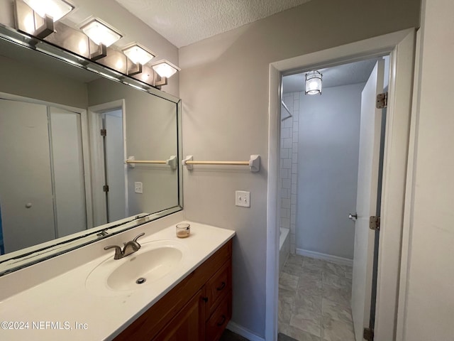 bathroom with vanity,  shower combination, and a textured ceiling