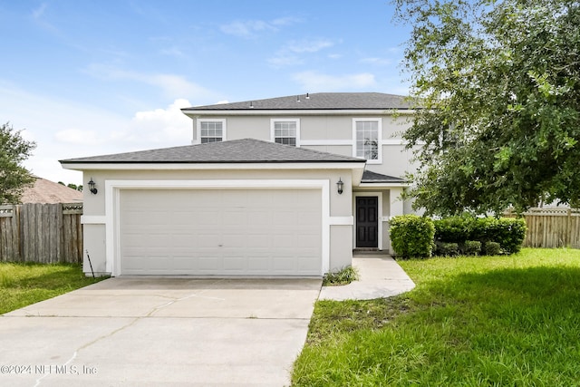 view of front of property featuring a garage and a front lawn