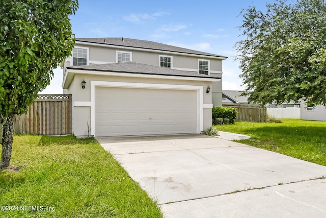 view of front property featuring a garage and a front lawn