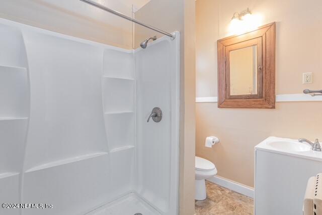 bathroom with vanity, a shower, and toilet