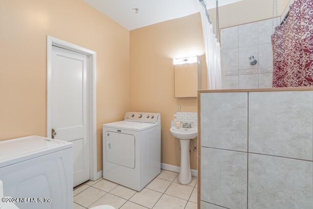 laundry room featuring washer / clothes dryer, light tile patterned floors, and sink