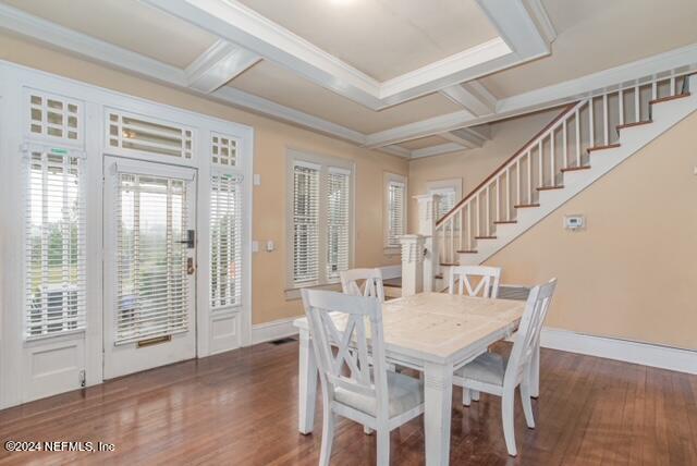 dining space featuring coffered ceiling, ornamental molding, dark hardwood / wood-style floors, and beam ceiling