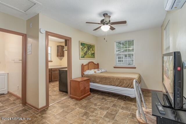 bedroom with an AC wall unit, ceiling fan, and ensuite bathroom