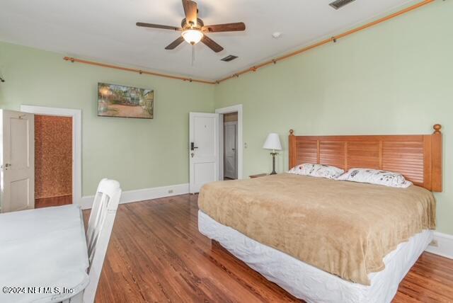 bedroom with dark wood-type flooring and ceiling fan