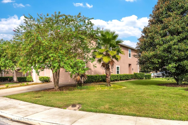 view of front of property featuring a front lawn and a garage