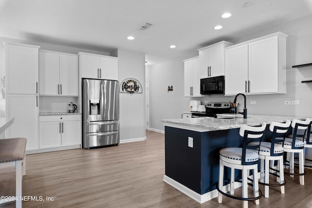 kitchen featuring white cabinets, stainless steel refrigerator with ice dispenser, and light wood-type flooring