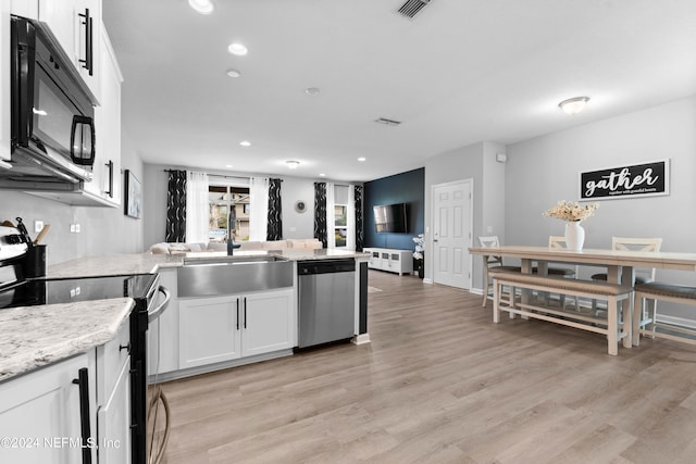 kitchen featuring light wood-type flooring, black appliances, sink, and white cabinets