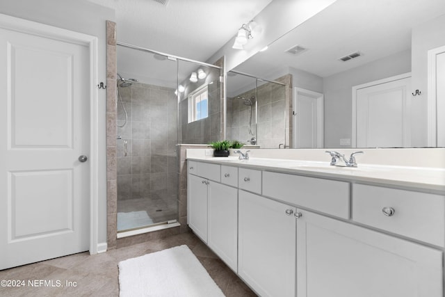 bathroom with tile patterned flooring, vanity, and a shower with shower door