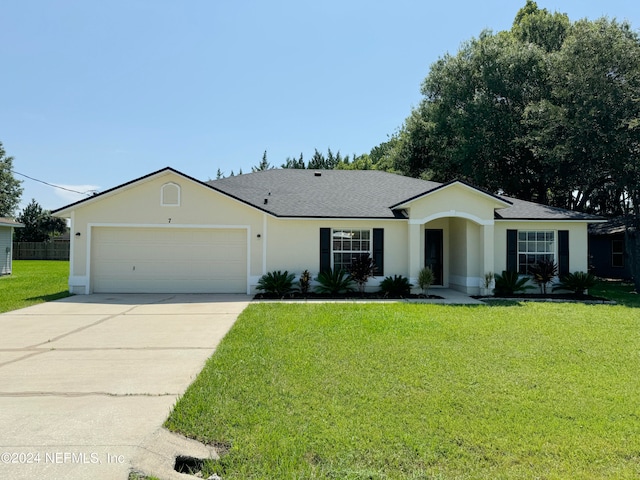 ranch-style house with a garage and a front lawn