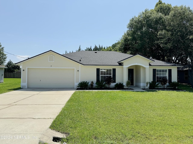 ranch-style home featuring concrete driveway, stucco siding, roof with shingles, a front yard, and a garage