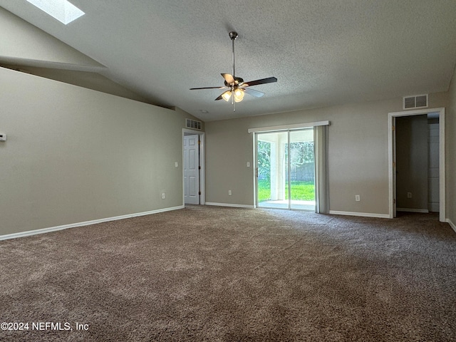 unfurnished room featuring a textured ceiling, vaulted ceiling with skylight, carpet flooring, and ceiling fan