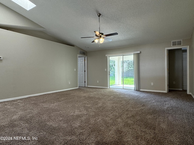 unfurnished room featuring lofted ceiling with skylight, a ceiling fan, carpet floors, and visible vents