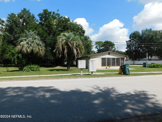 view of front of house featuring a sunroom and a front yard