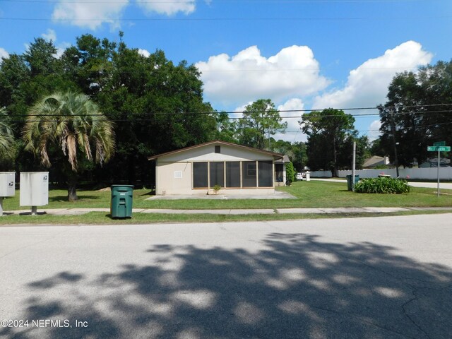 view of front of house with a front lawn and a sunroom