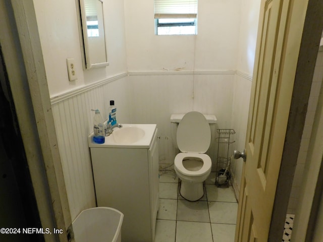 bathroom with tile patterned floors, plenty of natural light, vanity, and toilet