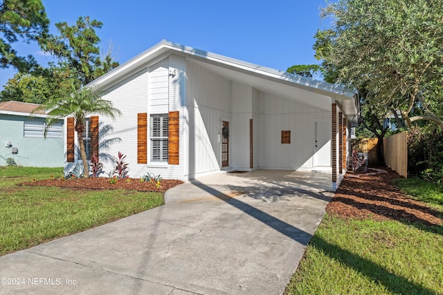 view of front of property with a front lawn and a carport