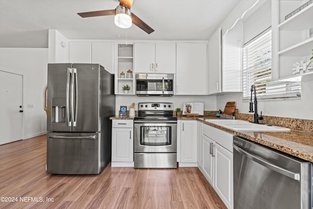 kitchen featuring ceiling fan, sink, white cabinetry, stainless steel appliances, and light hardwood / wood-style floors