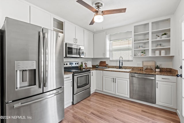 kitchen featuring appliances with stainless steel finishes, light hardwood / wood-style floors, white cabinets, ceiling fan, and sink