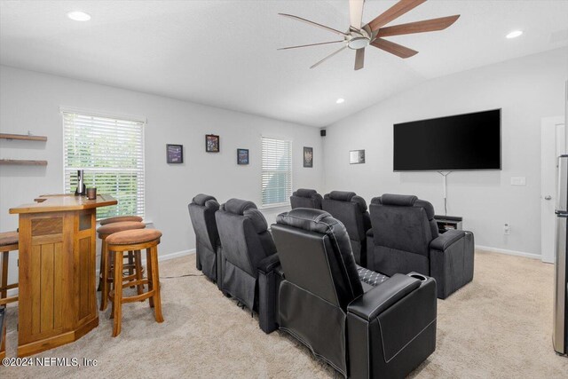 carpeted cinema room with vaulted ceiling and ceiling fan