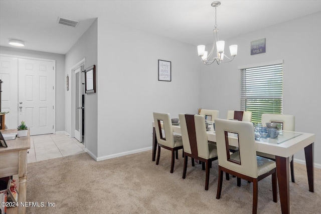 carpeted dining space with a chandelier