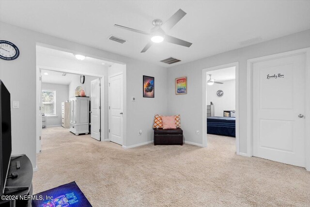 interior space featuring light carpet and ceiling fan