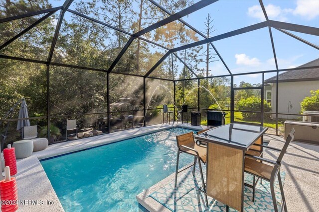 view of swimming pool with glass enclosure and a patio area