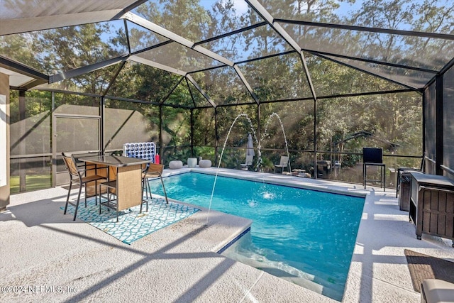 pool with glass enclosure and a patio