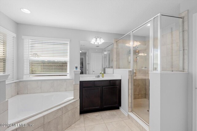 bathroom with independent shower and bath, vanity, and tile patterned floors