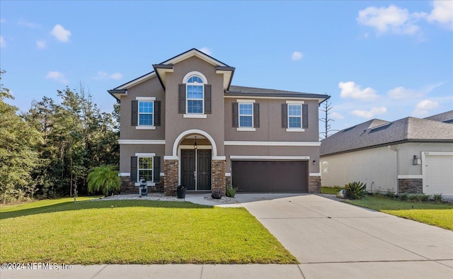 view of front facade featuring stone siding, a front yard, driveway, and stucco siding
