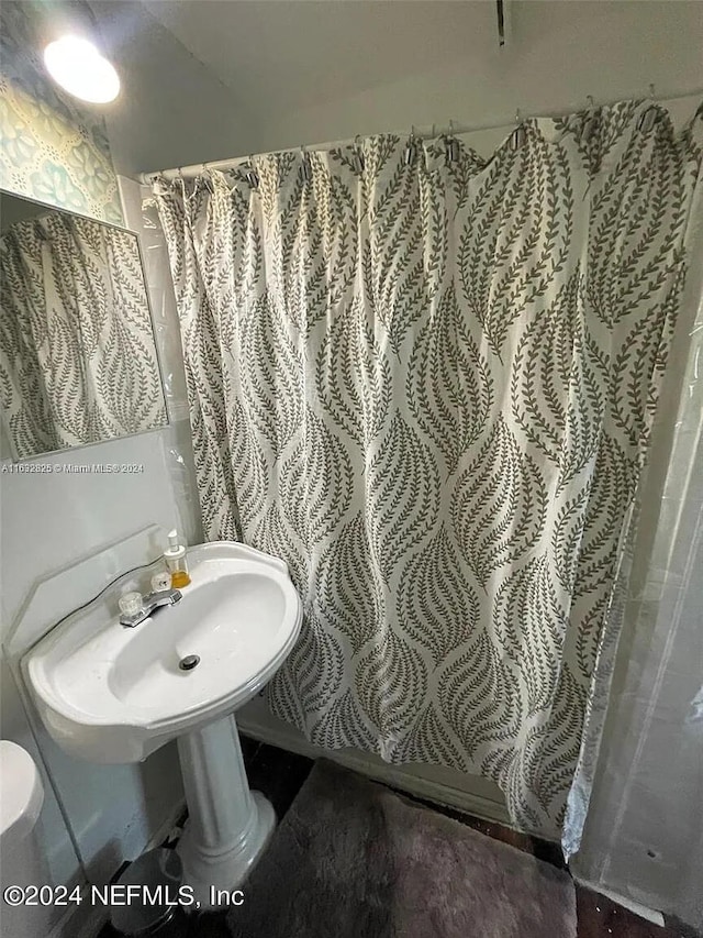 bathroom with toilet and curtained shower