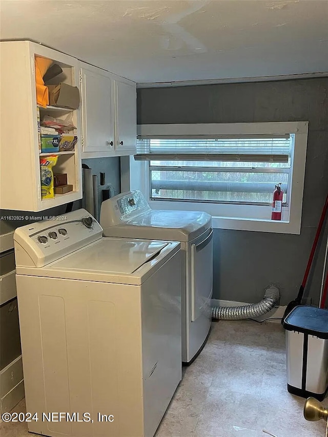 laundry room featuring plenty of natural light, washer and dryer, and cabinets