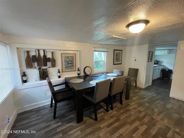 dining area with a textured ceiling and dark hardwood / wood-style flooring