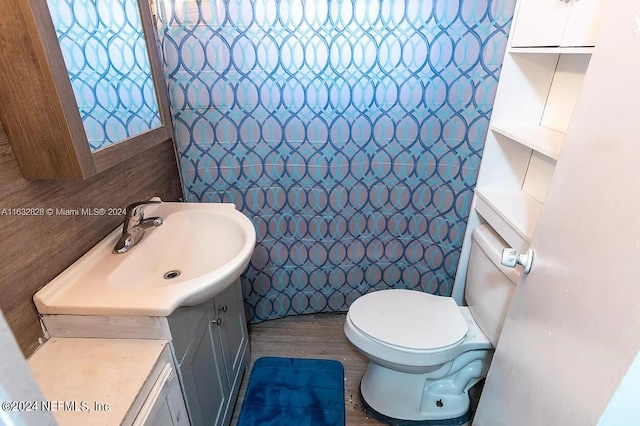 bathroom featuring tile walls, hardwood / wood-style floors, vanity, and toilet