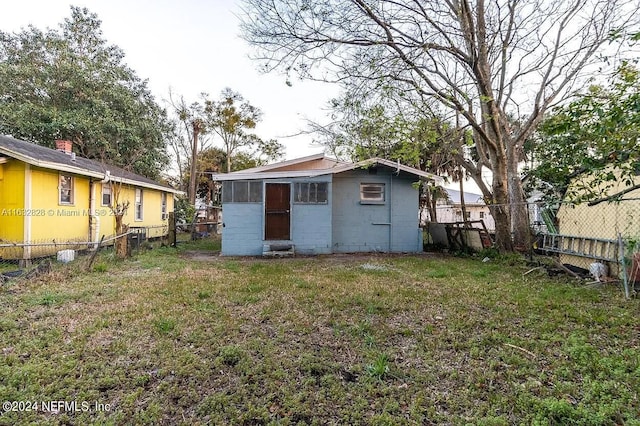 rear view of property with a yard and an outdoor structure